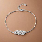 A sterling silver bracelet with a floral pattern of cubic zirconia stones, featuring an adjustable clasp.